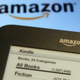 An Amazon Kindle held next to an Amazon logo in 2012.